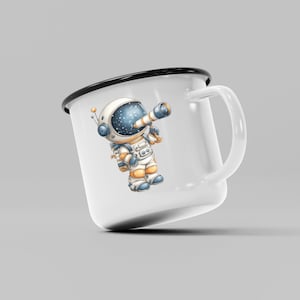 May include: White enamel mug with a black rim and handle. The mug features a cartoon astronaut with a telescope, dressed in a white and orange spacesuit. The astronaut's helmet shows a starry night sky.