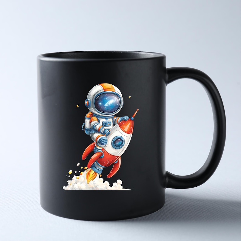 May include: Black ceramic mug featuring a colorful illustration of an astronaut riding a red and white rocket ship. The astronaut is wearing a white and orange spacesuit and helmet. The rocket has blue accents and is emitting flames and smoke.