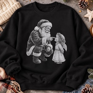 Schwarzes Weihnachts-Sweatshirt mit Vintage-Motiv: Weihnachtsmann stupst Christkindl an die Nase. Linker Ärmel umgeschlagen.