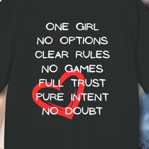 Może przedstawiać: Biały ceramiczny kubek z czarnym uchwytem i napisem "But First, Coffee" pogrubioną czcionką. Kubek ma około 10 cm wysokości i błyszczące wykończenie.