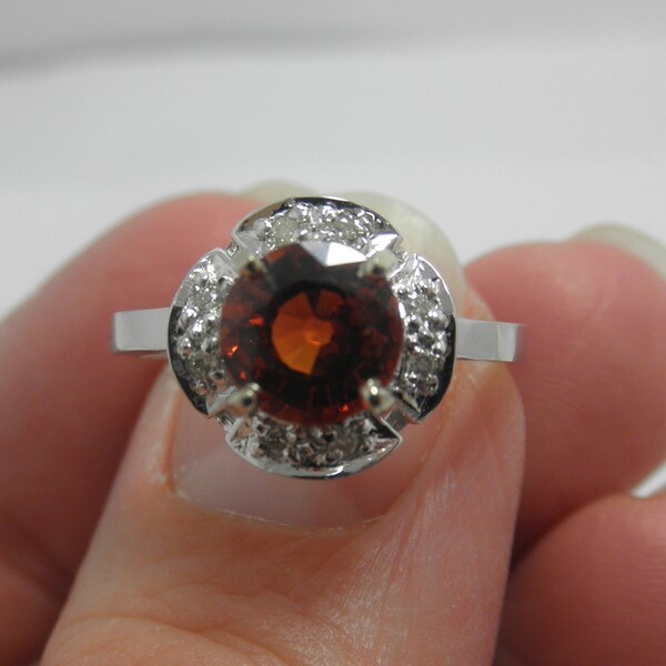 1.2 CT Spessartine garnet ring with a  diamond halo around the stone in 14KT white gold