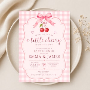 May include: A rectangular baby shower invitation card featuring a light pink and white gingham pattern. The design includes a pink bow, two red cherries, and text reading: Sweet as can be a little cherry is on the way, Emma & James, July 18.