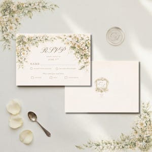 Pu&ograve; includere: Biglietto RSVP color crema con decorazioni floreali e la scritta "RSVP". Include una busta abbinata e un sigillo di cera. Il biglietto presenta caselle di controllo per le scelte dei pasti e uno spazio per il nome dell'ospite.