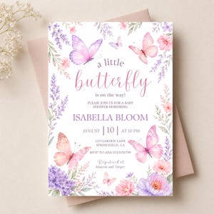 May include: A white rectangular baby shower invitation card featuring watercolor illustrations of pink and purple butterflies, lavender sprigs, and floral clusters. The text reads: a little butterfly is on the way! ISABELLA BLOOM AUGUST 10 AT 10 PM.