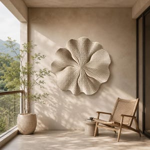 May include: A large, circular, beige wall sculpture featuring a textured, pleated, flower-like design with radiating lines. The piece is mounted on a smooth, light-colored wall, creating a focal point with its organic, wavy, and symmetrical shape.