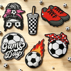 Könnte beinhalten: Eine Sammlung von aufgestickten Aufnähern mit Fußball-Motiven. Enthält einen Fußball, Fußballschuhe, einen Becher und einen Aufnäher mit den Worten "Game Day". Die Aufnäher sind schwarz, weiß, rot und orange.