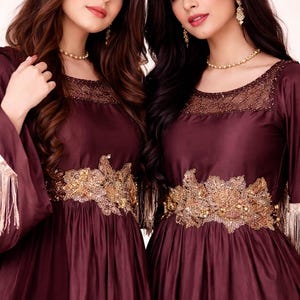Abito lungo in seta grezza color marrone cioccolato, con inserti dorati e maniche a frange, stile abaya.