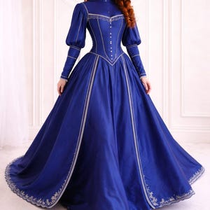 May include: A white ceramic mug with a black handle and the text "But First, Coffee" in a black, handwritten-style font. The mug is on a white surface.