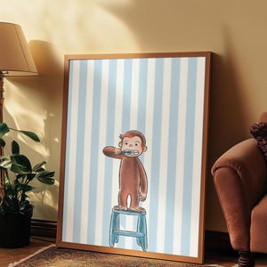 May include: Framed print of a brown monkey brushing its teeth, standing on a blue stool. The background has vertical blue and white stripes. The print is in a wooden frame and leans against a wall.