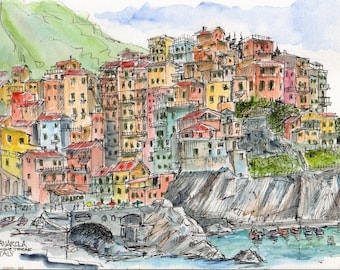 May include: Watercolor sketch of Manarola, Italy, featuring colorful buildings stacked on a cliffside. The artwork depicts a coastal village with vibrant hues of red, yellow, and pink, with a bridge and boats in the foreground.