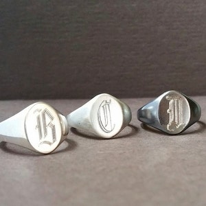 以下が含まれることがあります： 楕円形のトップを持つ銀製のシグネットリング3つ。リングには、ゴシック体でB、C、Iの文字が刻まれています。