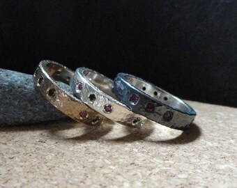 Anillo texturizado Stack Rings en plata de ley maciza, plata oxidada o bronce con rubíes engastados en estilo gitano y diamantes negros. Joyería fina.