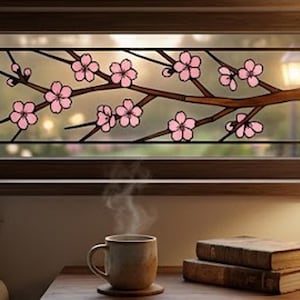 May include: A stained glass window with a brown frame features a branch of pink cherry blossoms. A cup of coffee sits on a wooden table with two books and a lamp. The scene evokes a sense of warmth and tranquility.