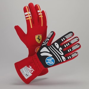 Peut inclure: Une paire de gants de course rouges avec des détails blancs et jaunes. L'un des gants présente le logo Ferrari, l'autre une paume noire avec des motifs blancs et le logo HP. Les gants portent le numéro 16 et la marque Puma.