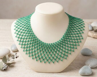 May include: A collar necklace crafted from small, vibrant green beads arranged in a repeating diamond-shaped lattice pattern. The piece features a wide, scalloped edge along the bottom, creating a structured, net-like design that rests flat.