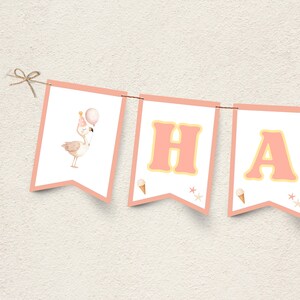 Może przedstawiać: Baner z różowymi i białymi proporczykami z napisem "HAPPY". Pierwszy proporczyk przedstawia flaminga trzymającego balon. Litery są różowe z żółtą obwódką. Na dole proporczyków znajdują się rożki lodów i gwiazdki.