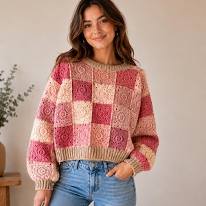 Può includere: Un maglione a maniche lunghe realizzato con un patchwork di quadrati all'uncinetto in varie tonalità di rosa, crema e rosa scuro. Il capo presenta un girocollo, polsini e orlo a coste in una tonalità beige neutra con un motivo floreale circolare.
