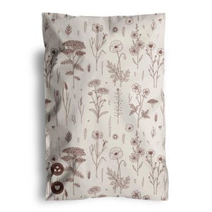 May include: A beige bag with a repeating pattern of brown botanical illustrations, including flowers and leaves. The bag has a rounded top and a few circular logos on the bottom left corner.