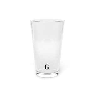 May include: A white ceramic mug with a black handle and the text "But First, Coffee" in a black, handwritten-style font. The mug is on a white surface.