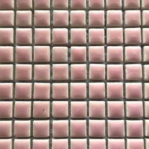 May include: Close-up of a mosaic tile sheet. The tiles are small, square, and a soft pink color. The grout lines are a light gray. The tiles are arranged in a grid pattern, creating a textured surface. Ideal for home decor projects.