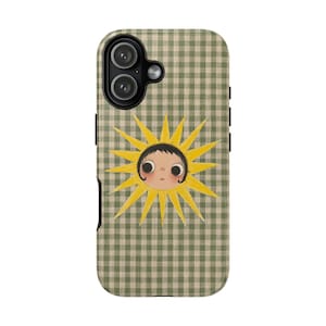 May include: A phone case featuring a green and white gingham check pattern. Centered on the case is a yellow sun illustration with a stylized face, featuring large dark eyes, dark hair, and rosy cheeks, surrounded by pointed yellow sun rays.