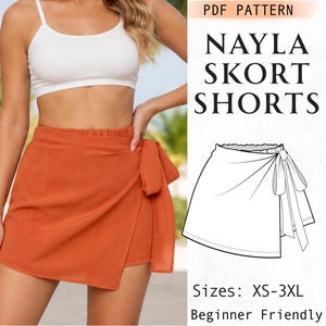 May include: A PDF pattern for Nayla Skort Shorts in sizes XS-3XL, featuring a beginner-friendly design. The image displays a burnt orange wrap-style skort with a side tie and a black and white line drawing illustration of the garment construction.