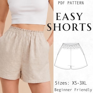 Può includere: Pantaloncini beige con vita elastica arricciata e tasche laterali. L'immagine include il testo PDF PATTERN EASY SHORTS, un disegno al tratto in bianco e nero dei pantaloncini e il testo Sizes: XS-3XL Beginner Friendly.
