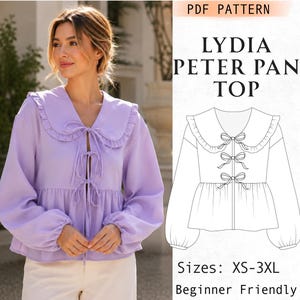 May include: A light purple long-sleeve top with a Peter Pan collar, ruffled edges, and three front tie closures. The image includes a black and white line drawing of the garment labeled LYDIA PETER PAN TOP with sizes listed as XS-3XL.