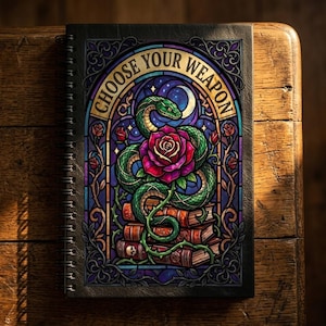May include: A spiral-bound notebook with a stained-glass design featuring a green snake coiled around a red rose, with the text "CHOOSE YOUR WEAPON". The design is set against a backdrop of books, a moon, and stars.
