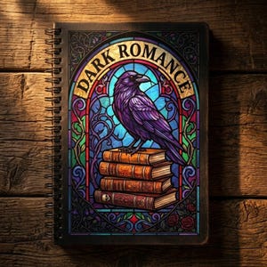 Può includere: Quaderno a spirale con un design a vetrata raffigurante un corvo viola appollaiato su una pila di libri. Le parole "DARK ROMANCE" sono arcuate sopra il corvo. Lo sfondo è una superficie di legno.