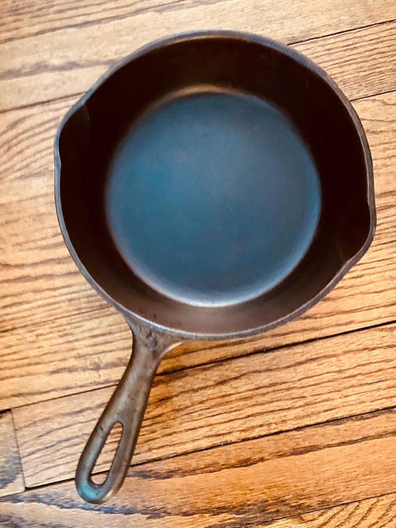May include: A black cast iron skillet with a long handle. The skillet is empty and has a smooth, dark surface.