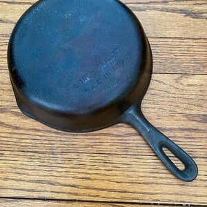 May include: A black cast iron skillet with a 10 inch diameter and a black handle. The skillet is marked "10 INCH SKILLET MADE IN USA".