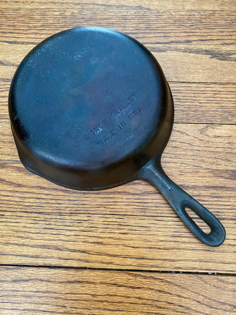 May include: A black cast iron skillet with a 10 inch diameter and a black handle. The skillet is marked "10 INCH SKILLET MADE IN USA".