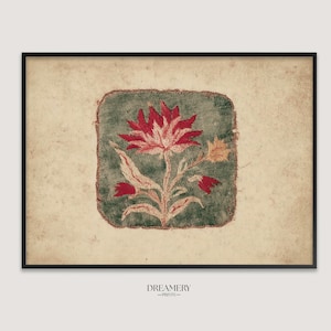 May include: A framed rectangular print featuring a central dark green square patch with a red and cream floral illustration. The background is a textured, aged cream paper. The text DREAMERY PRINTS is centered below the frame in black.