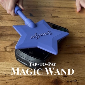 May include: A purple star-shaped tap-to-pay wand featuring the name Jennifer embossed on the surface. The wand is positioned over a black payment terminal. The text TAP-TO-PAY MAGIC WAND is displayed in white at the bottom of the image.