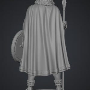 May include: A gray 3D rendered figurine of a standing figure viewed from the back. The figure wears a long, flowing cape, textured leg wraps, and sandals. It holds a tall spear in one hand and a round shield in the other, all set upon a circular base.