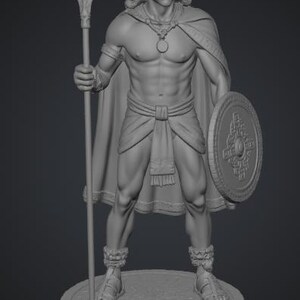 May include: A gray monochromatic figurine of a warrior standing on a circular base. The figure wears a headband, a cape, a loincloth, and sandals, holding a long spear in the right hand and a round shield with geometric patterns in the left hand.
