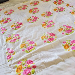 Puede incluir: Un edred&oacute;n blanco con un patr&oacute;n floral. Las flores son rosas, amarillas y verdes. El edred&oacute;n est&aacute; hecho de una tela suave y c&oacute;moda.