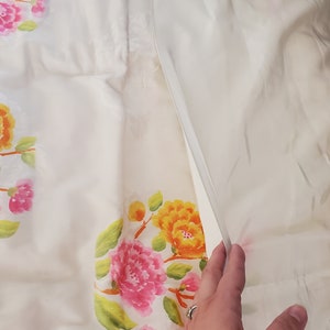 Puede incluir: Bedding blanco floral con un patr&oacute;n floral rosa y amarillo. La ropa de cama est&aacute; hecha de una tela suave y ligera.