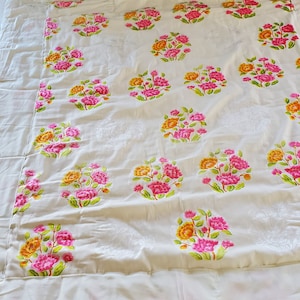 Puede incluir: Bedding blanco con un patr&oacute;n floral. Las flores son rosas, amarillas y verdes. La ropa de cama tiene un borde blanco.