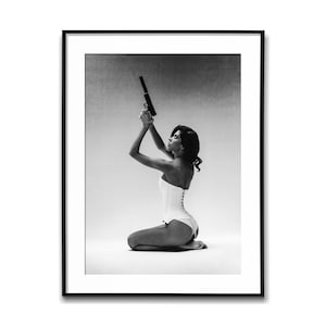 Modelka w gorsecie trzymająca pistolet w stronę sufitu; czarno-biały plakat ścienny, wydruk w stylu vintage, wydruki fotograficzne, plakat estetyczny