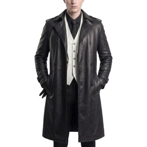 Könnte beinhalten: Ein schwarzer Ledertrenchcoat mit doppelreihiger Knopfleiste, breitem Revers und Schulterklappen. Der Mantel wird über einer weißen Weste, einem schwarzen Hemd und einer schwarzen Krawatte getragen, dazu sind eine schwarze Hose und Handschuhe sichtbar.