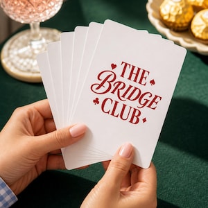 Poker Cards custom bridge playing cards fanned by manicured hands at a green felt table — personalized card game gift, card backs fully visible in a preppy editorial close-up.