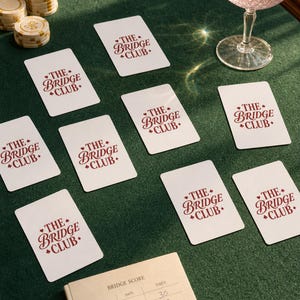 Poker Cards bridge playing card deck dealt across green baize felt — custom card game gift with chips and cocktail, preppy card-night editorial lifestyle photography.