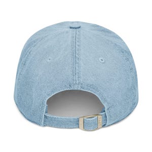 Light blue embroidered dad hat with white lowercase text “dot crak bam,” minimalist baseball cap inspired by Mahjong tiles, casual adjustable cotton cap on a clean white background.