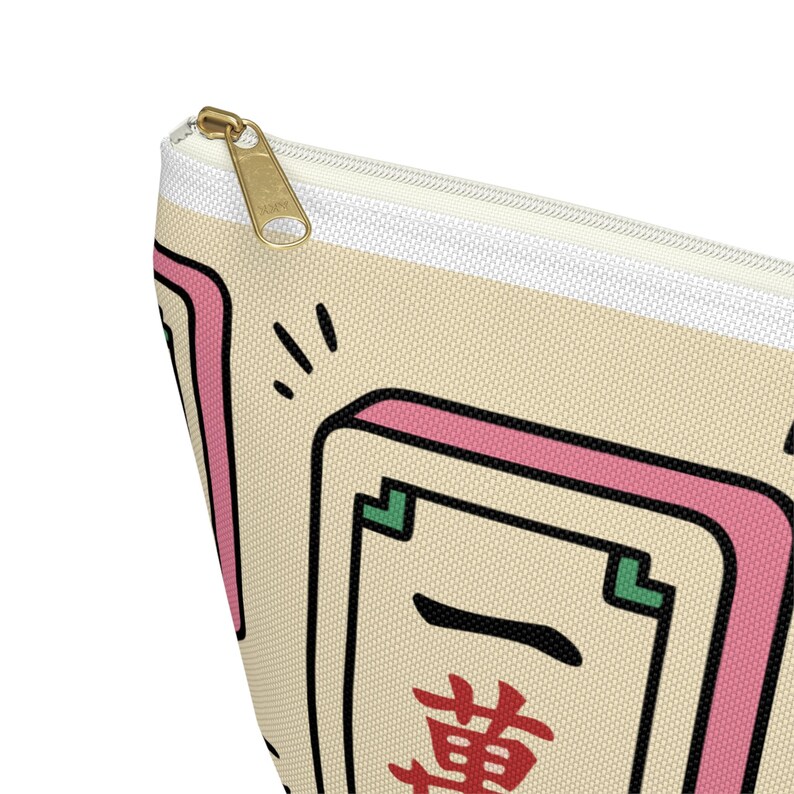 Mahjong tile canvas pouch zipper bag — mahjong lover gift featuring a kawaii-style illustrated tile print in pink and cream, shown close up to highlight the gold zipper and bold red Chinese character design.