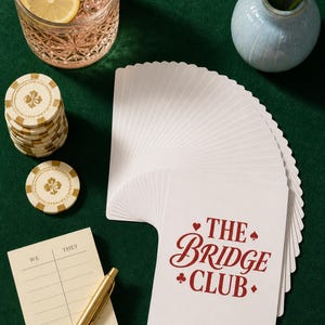 Poker Cards playing card deck fanned wide on green baize — bridge card game gift showing printed card backs with chips, cocktail, and score pad in a preppy editorial flat lay.