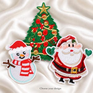 May include: Three embroidered patches featuring holiday themes: a green Christmas tree with gold and red ornaments, a white snowman wearing a red hat and striped scarf, and a Santa Claus in a red suit with green mittens. Text reads: Choose your design.