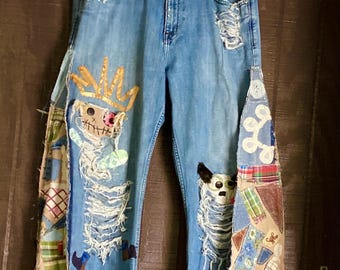 Jeans in denim patchwork riciclati con bambole scheletriche coronate – Jeans rielaborati in stile arte popolare – Un capo d'arte indossabile unico nel suo genere - jeans mostro gatto-cane