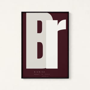 May include: A framed art print featuring the letters "Br" in large, bold typography. The "B" is a light gray, and the "r" is white, set against a deep burgundy background. The word "bromine" and the phrase "eager to react" are printed at the bottom.